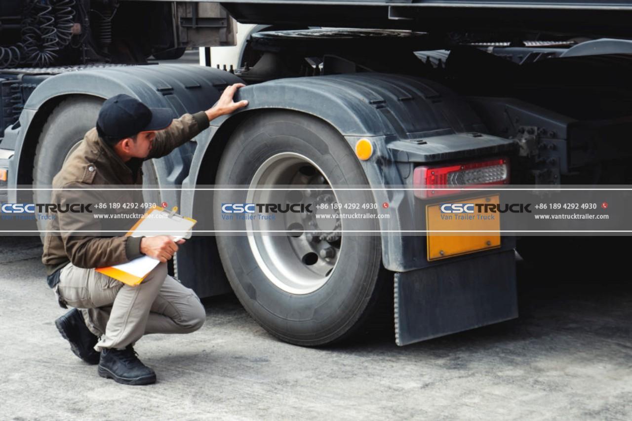 Truck driver inspecting safety check a truck tires